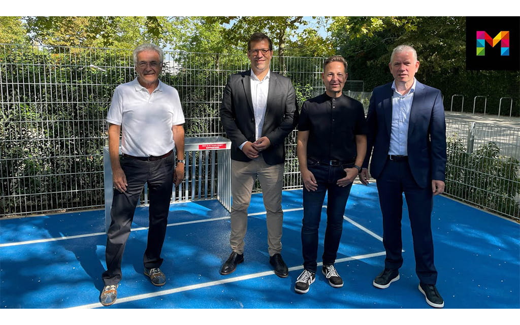 Vier Männer auf einem Sportplatz 