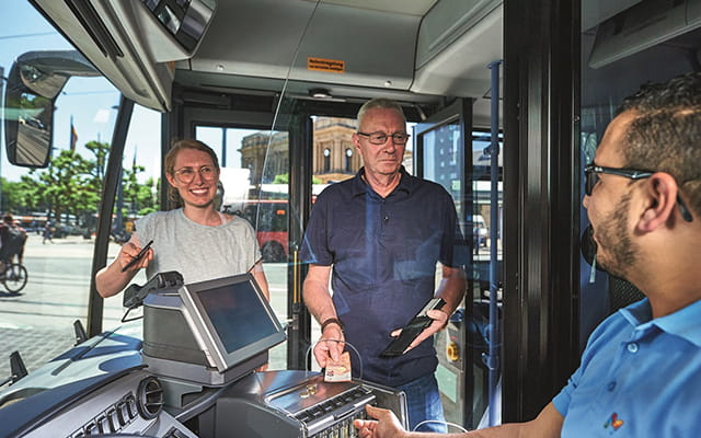 Ein Paar bezahlt kontaktlos beim Busfahrer