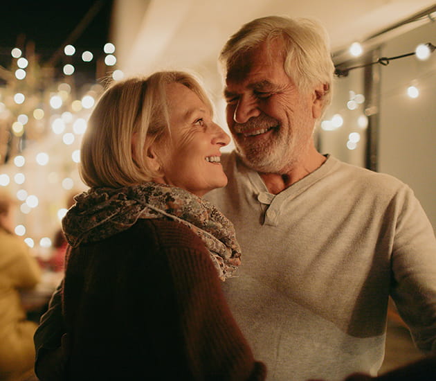 Älteres Paar steht Arm in Arm auf einer Veranstaltung