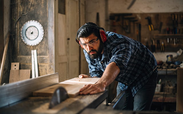 Ein Tischler sägt ein Holzbrett zurecht