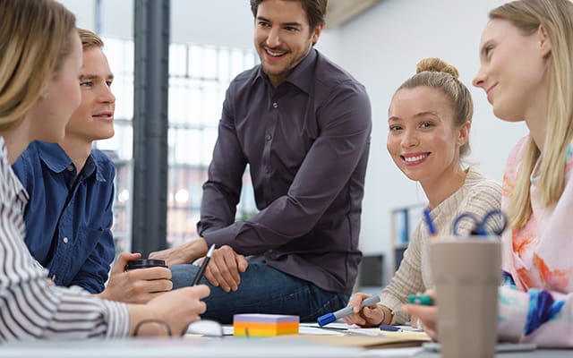 Junge Menschen sitzen auf der Arbeit zusammen Junge Menschen sitzen auf der Arbeit zusammen