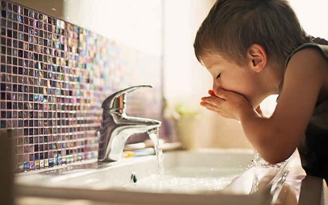 Kleiner Junge trinkt Leitungswasser aus dem Wasserhahn Kleiner Junge trinkt Leitungswasser aus dem Wasserhahn