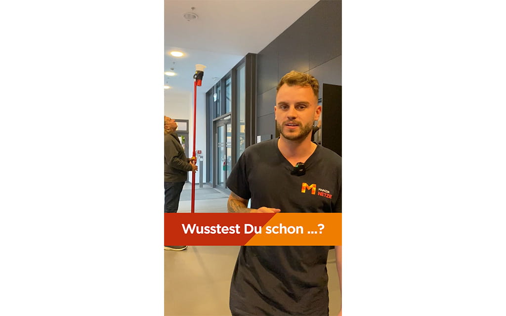 Mann mit Mainzer Netze Shirt steht im Flur 