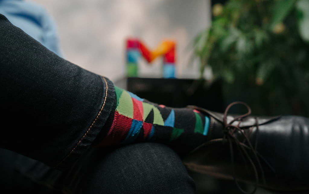 Ein Bein von einem Mann mit bunten Dreiecken auf den Socken