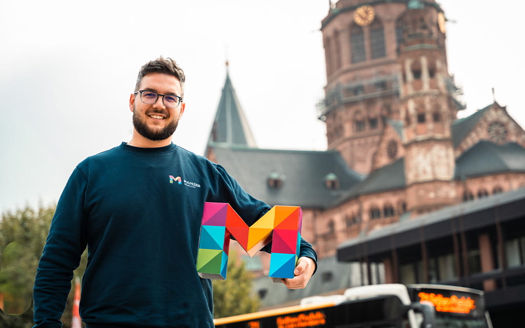 Mann mit bunten M im Arm