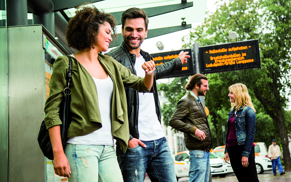 Junge Menschen stehen bei Regen an einer Haltestelle der Mainzer Mobilität 3 Junge Menschen stehen bei Regen an einer Haltestelle der Mainzer Mobilität 3
