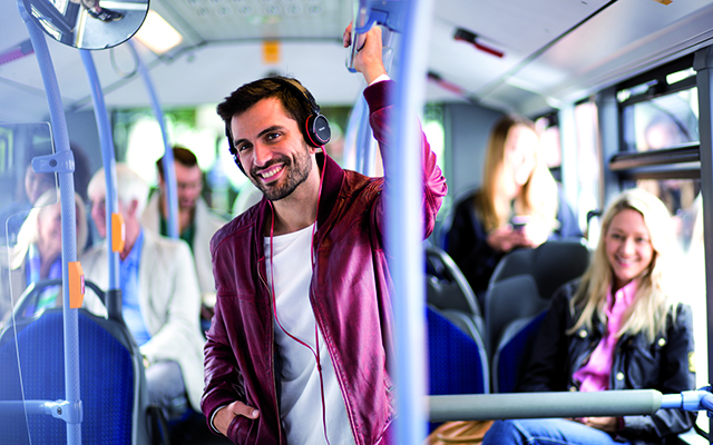 Junger Mann steht mit Kopfhörern im Bus 2 Junger Mann steht mit Kopfhörern im Bus 2
