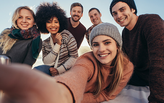 Freunde nehmen während einer Beachparty ein Selfie auf 2 Freunde nehmen während einer Beachparty ein Selfie auf 2
